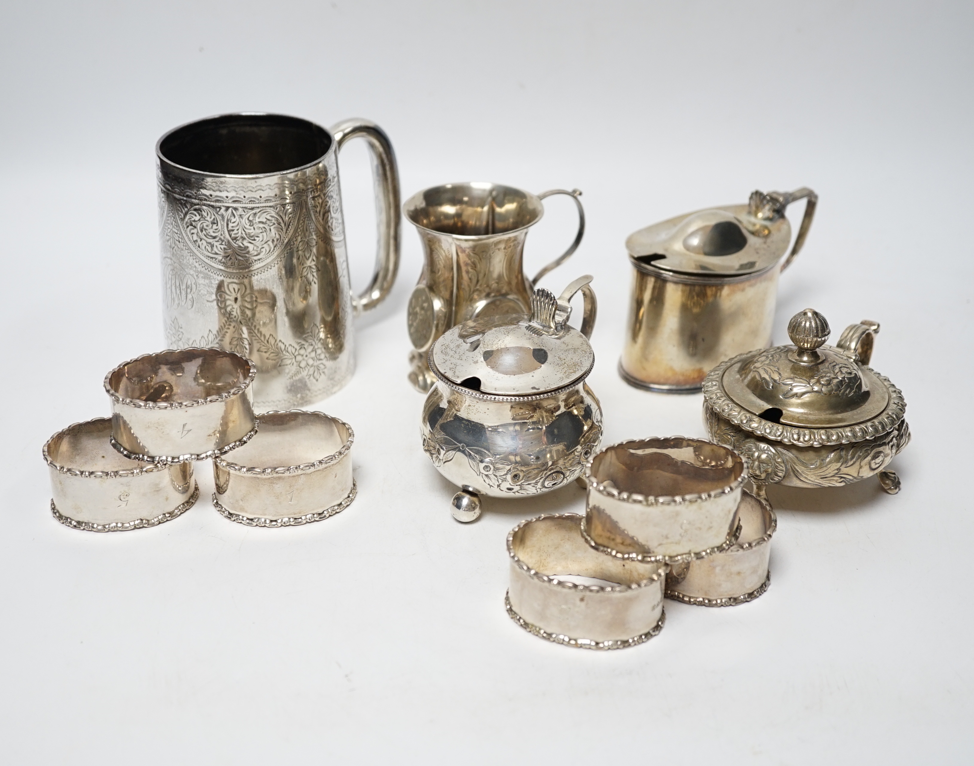 A late Victorian engraved silver mug, Hilliard & Thomason, Birmingham, 1900, 10.2cm, three assorted silver mustard pots including Victorian, a small Victorian silver christening mug and a set of six silver napkin rings,